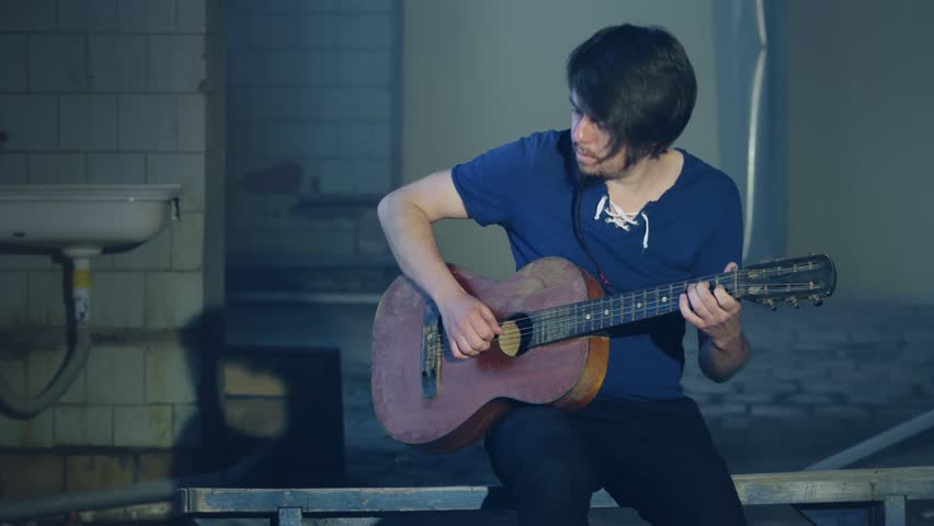 Musician guitarist playing on acoustic guitar