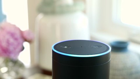 Amazon Alexa / Amazon Echo is on a table near Window.  Activates. For editorial use.