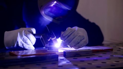 Close up shot of a mechanic who is engaged in the argon welding of an aluminum product