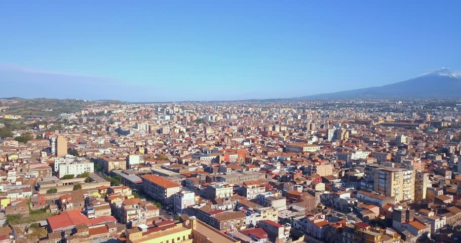 Aerial view on the dome of Cathedral in Catania on the background of volcano Etna in the snow.. The view of the city of Catania with the view of Etna volcano, Sicily, Italy. 