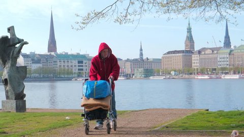 LUBECK, GERMANY - April 22, 2018. Homeless man on a street with trolley in center of Hamburg, Germany