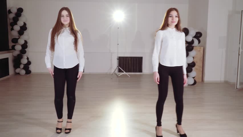 Two young girls are dancing in the dance studio. Evening dance rehearsal.