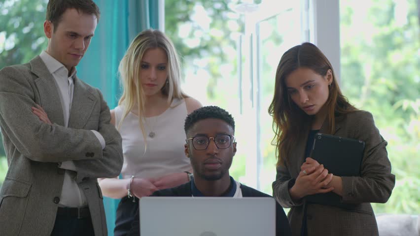 Young group of professional workers, staring in to colleagues screen right in to camera as if there is something wrong, distrusting or fraudulent, start up diverse. Slides out Royalty-Free Stock Footage #1011176774