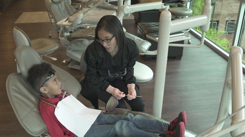 Jib shot of a dentist examining a boy 스톡 비디오