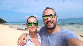 Happy couple taking selfie photos, recording video on beach, super slow motion
