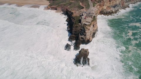 Flight near Rock and Lighthouse near City of Nazare, a very famous place for surfers