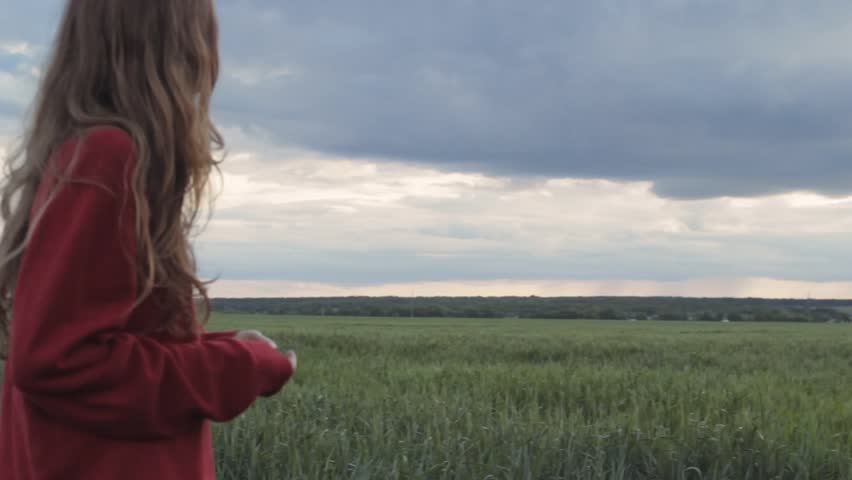 Pretty girl on field in red  | Shutterstock HD Video #1011195089