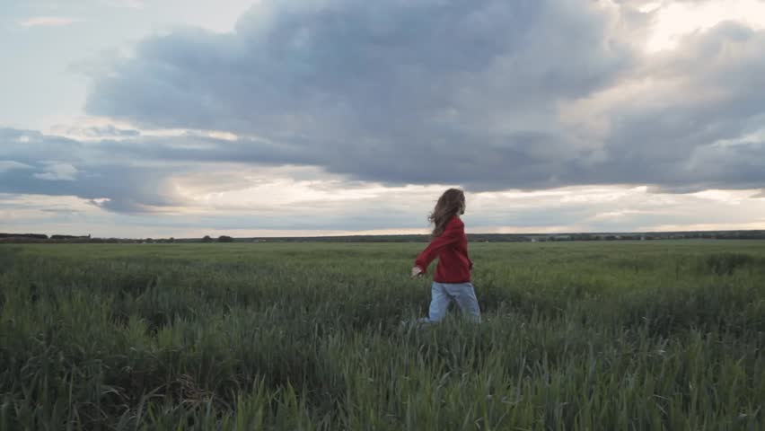 Pretty girl on field in red  | Shutterstock HD Video #1011195095