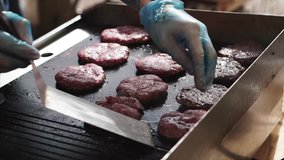 Make burgers on the grill restaurant. Clip. Burgers cooking on a gas grill in the evening sun