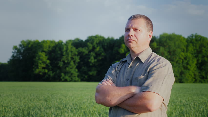 Confident middle-aged farmer standing in the field. Master of business concept. Steadicam shot