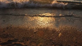 
waves are beating against the sea shore at sunset. video