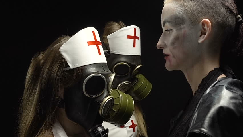 Woman in black and two girls in gas mask