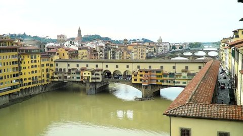 Zoom in shot of Ponte Vecchio bridge and Arno River in Florence Italy during a sunny day