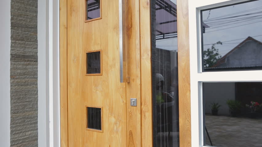 Happy young woman in casual clothes, smiling pose in front of her house