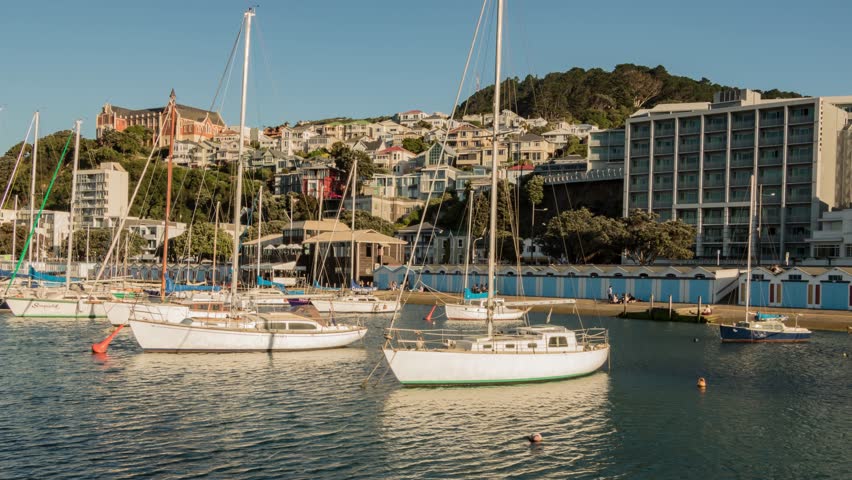 Time lapse at wellington new zealand marina, sun sets over boats and church on hill.