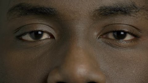 Close up dark-skinned man closed eyes. Afro-american male person is openes his eyes close up. Black man eyes.
