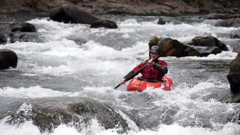 Super slow motion of a man kayaking a wayerfall