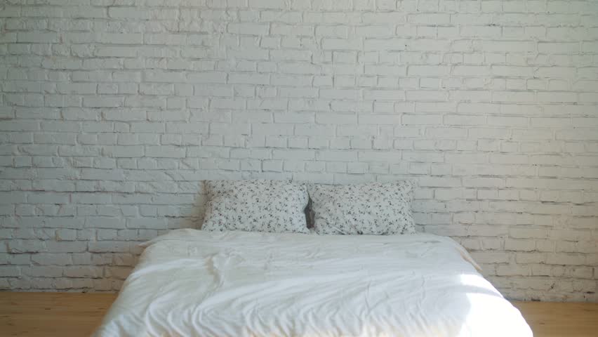 Happy woman jumping and dancing on bed high shot