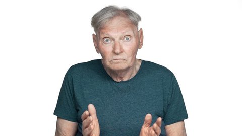 Portrait of embarrassed retired man 80s having gray hair in basic t-shirt shrugging and throwing up hands with helpless emotions in slow motion, isolated over white background
