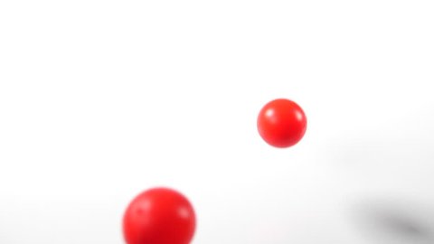 bouncing balls popping and rolling onto around on a white background, red ping-pong plastic fun ball movement.