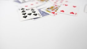 Close up of a playing cards with dice thrown onto a white surface background. Gambling or playing board games. Dolly over the top of game. 
