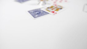 Close up of a playing cards with dice thrown onto a white surface background. Gambling or playing board games. Dolly over the top of game. 
