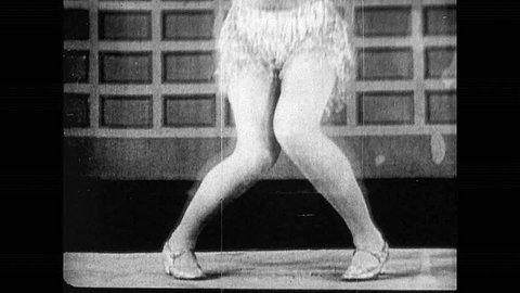 1920s: Woman's legs as she dances. Two women dancing together. Group of women dancing in circle in public. Large crowd watches women dance.