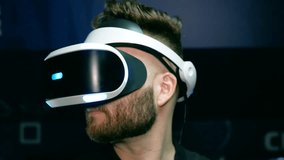 Bearded guy in virtual reality glasses turns his head.