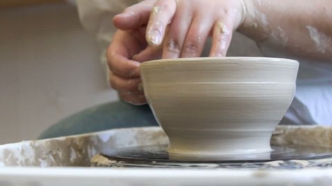 pottery handicraft skills. traditional art of creating ceramics. potter modeling clay on turning wheel