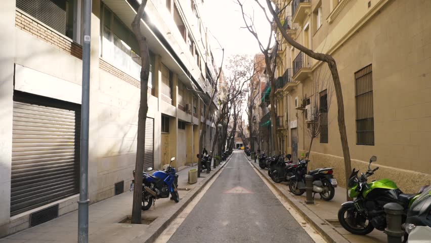 Narrow pedestrian greek street between old buildings in Lefkada town, Greece. Stock. Narrow street between houses with motorcycles
