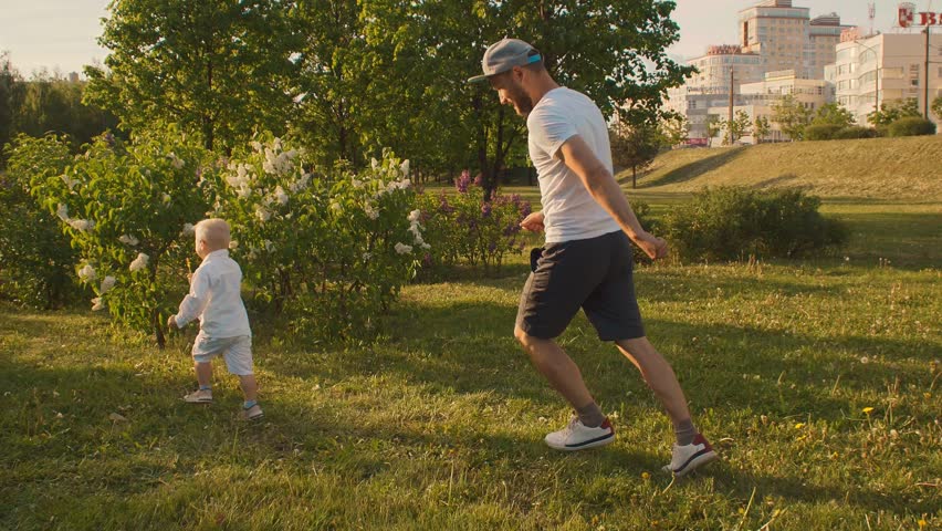 Daddy plays with a child in a park in the fresh air