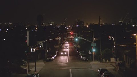 Night to morning time lapse of a busy street near the San Diego shipyards.  Working cranes move back and forth in the distance.   
