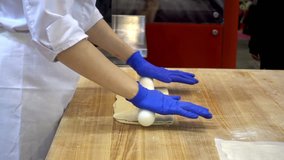 The hands of the woman cooks roll the dough with a rolling pin. Preparation of the test for baking. HD video