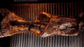 Fried lamb carcass rotates on a spit. HD video