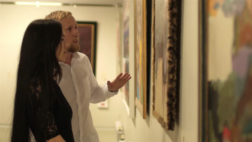 Couple discuss paintings in the museum's art gallery