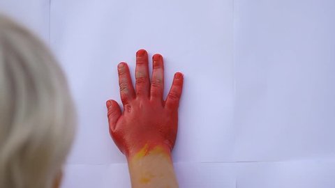 Close up of cute child's hands making color handprints on the white  wall with lovely mother in slow motion 50fps