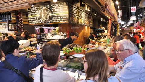 Barcelona, Spain - May 14, 2018: La Boqueria market - Tapas bar serving tourists and locals with traditional Spanish Tapas (Fresh local appetizers
