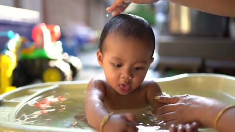 Asian baby girl take a bath at home with mom