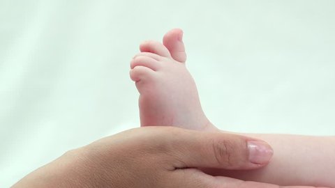 Detail of mother hands holding baby sole, delicate touch of little foot