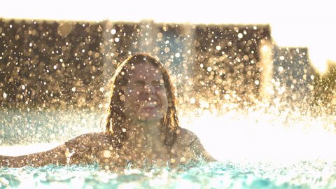Water drops falling on a woman in a pool
