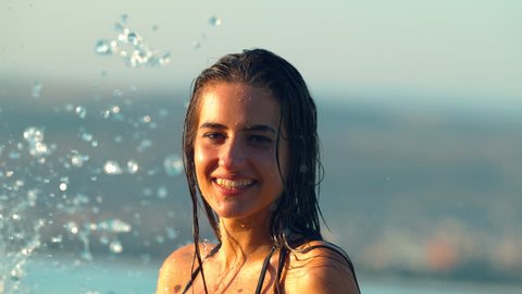 Young woman being splashed into face