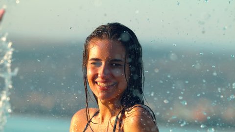 Young woman being splashed with water into her face