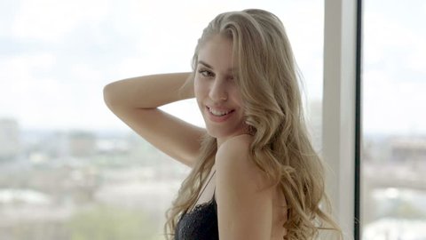 Portrait of beautiful blonde young woman in black lingerie. Slow motion. HD