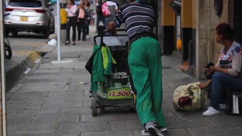 Medellin, Colombia - May 1, 2018: Disabled street seller working on a street in Colombia