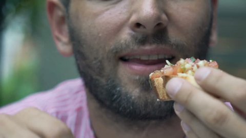 Close up of male mouth eating sandwich, super slow motion 120fps
