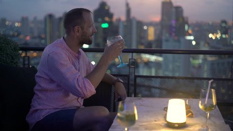 Young man admire view and drinking cocktail in skybar
