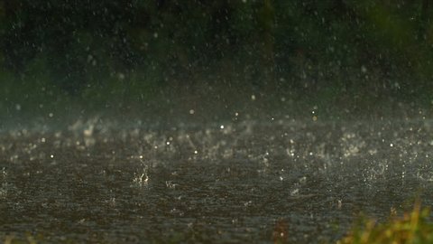 Raindrops splashing on the road, slow motion