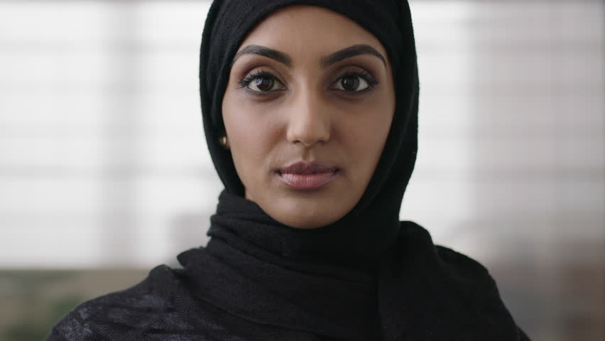 close up portrait of independent young muslim business woman looking serious confident at camera wearing traditional headscarf slow motion Royalty-Free Stock Footage #1011299813