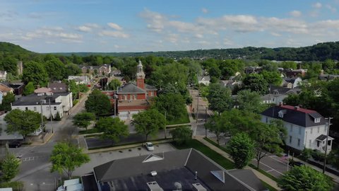 A slow moving forward wide aerial establishing shot of the steeple of a city hall in the small New England town. Pittsburgh suburbs.  	Available in 4K.