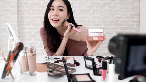 Young beautiful Asian woman professional beauty vlogger or blogger recording make up tutorial to share on social media